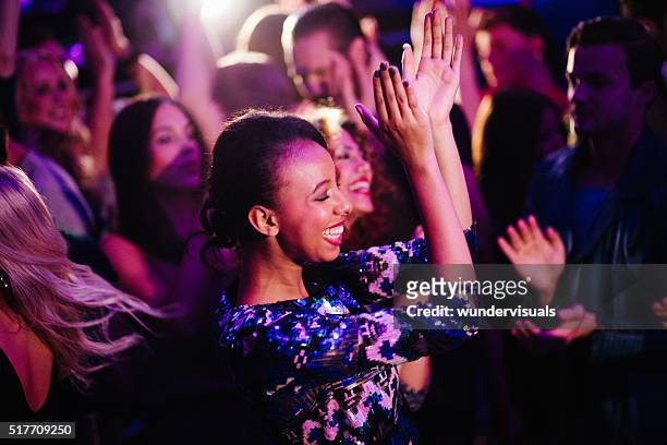 african descent girl enjoys dancing with friends in nigh club - klöver nummerkort bildbanksfoton och bilder