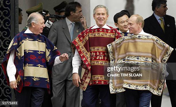 President George W. Bush wearing a traditional Chilean poncho walks with Chilean President Ricardo Lagos and Russian President Vladimir Putin to the...