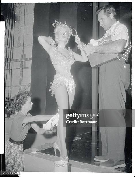 Lovely singing and dancing star Gloria DeHaven is carefully dabbed by makeup attendants as she prepares to go before the cameras on Paramount's set...