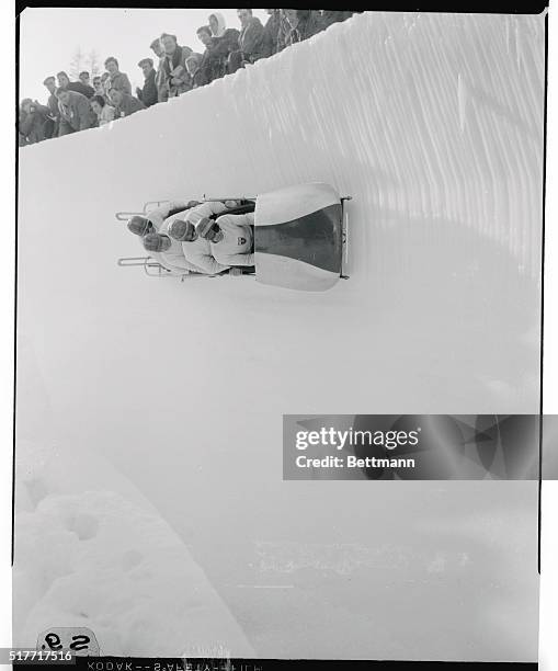 Whizzing right under the onlookers' noses, Switzerland's number one bobsled team climbs high on the ice bank to come in a close second to the Swiss...