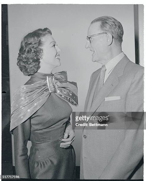 Loretta Young, wearing an eye-catching bow, plays hostess to Major General Charles W. Christenberry on the set of her filmed television program. As...