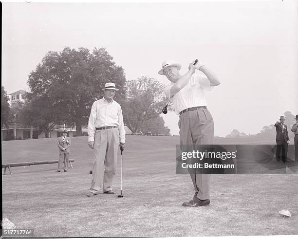 Augusta, Ga.: With golf pro Ed Dudley admiring his form, President-Elect Dwight Eisenhower is shown getting off a drive on the Augusta National Golf...