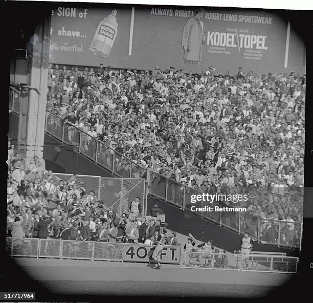 Pirates left fielder Gino Cimoli joins the fans in starting up at Mickey Mantle's long run blast as it falls into the left field stands in the fourth...
