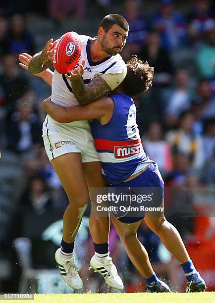 Clancee Pearce of the Dockers is tackled by Luke Dahlhaus of the Bulldogs during the round one AFL match between the Western Bulldogs and the...