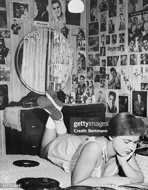 Teenager Ruby Hoff lounges on her bed, surrounded by photos of Elvis Presley, listening to Elvis.