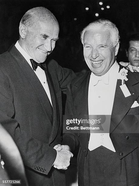 Paris, France: Charlie Chaplin shakes hands with Hollywood producer Sam Goldwyn at Moulin Rouge Cabaret during "Little White Beds" ball. Chaplin was...