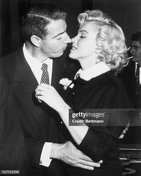 Joe DiMaggio and Marilyn Monroe kiss following their marriage ceremony in a judge's chambers in San Francisco, California.