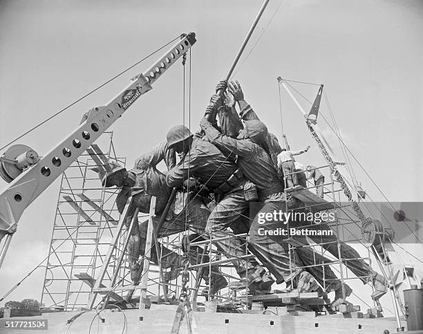 Workmen are shown putting the finishing touches on the Iwo Jima statue which will be on the Virginia side of the Potomac River. The heavy rifle of a...