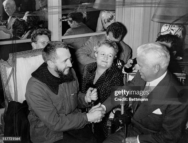 Charles Chaplin movie comedian, is shown shaking hands with Abbe Pierre, famous bearded priest of Paris, after the comedian donated over half a...