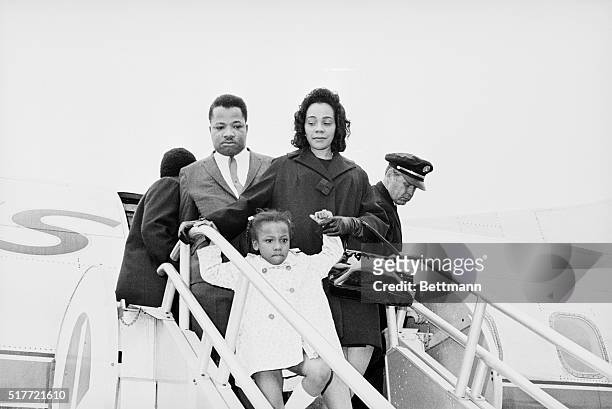 Mrs. Martin Luther King holding the hand of her daughter Bernice Albertina, and A. D. King, brother of the famed Civil Rights leader, leaves plane...