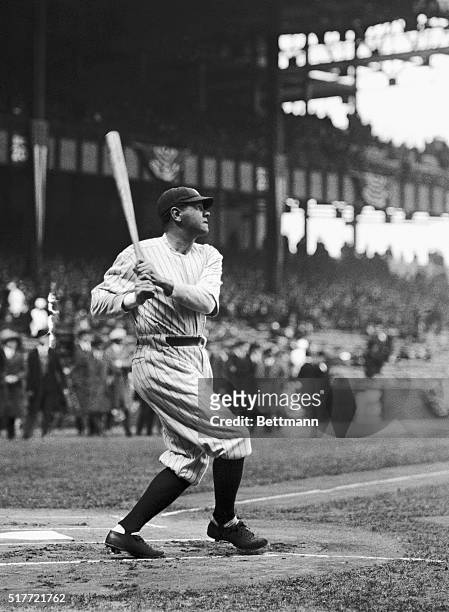 New York Yankees slugger Babe Ruth watches a towering drive of his sail towards the outfield wall.
