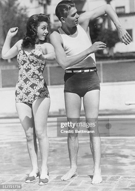 Beverly Hills, Calif.: This photo shows GOP Presidential candidate Ronald Reagan giving a swimming lesson to the late actress Susan Hayward when both...