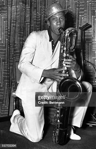 Jesse Owens, crack speedster in the 100-meter dash, and outstanding running broad jumper, plays the sax while idling away the hours at the Hotel...