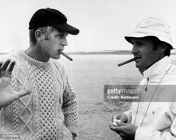 Smoking cigars, actor Steve McQueen and director Norman Jewison discuss a scene from the movie The Thomas Crown Affair.