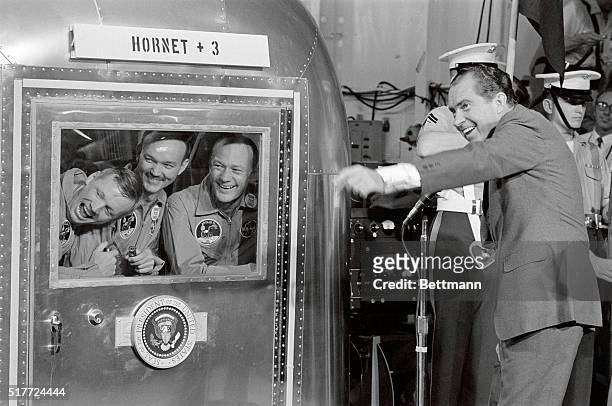 The astronauts of Apollo 11 - left to right, Neil Armstrong, Michael Collins, and Buzz Aldrin - react with amusement to something President Nixon has...
