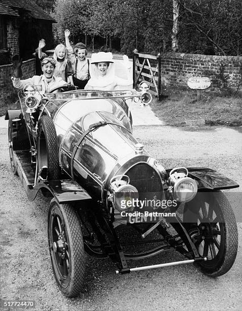 In a photograph from the 1968 musical Chitty Chitty Bang Bang, cast members Dick Van Dyke, Heather Ripley, Adrian Hall, and Sally Ann Howes wave from...