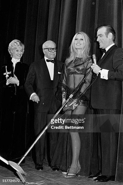 Paris: French film star Brigitte Bardot, wearing a long transparent dark gown with a bodice over a silvery micro-skirt, receives the award "Queen of...