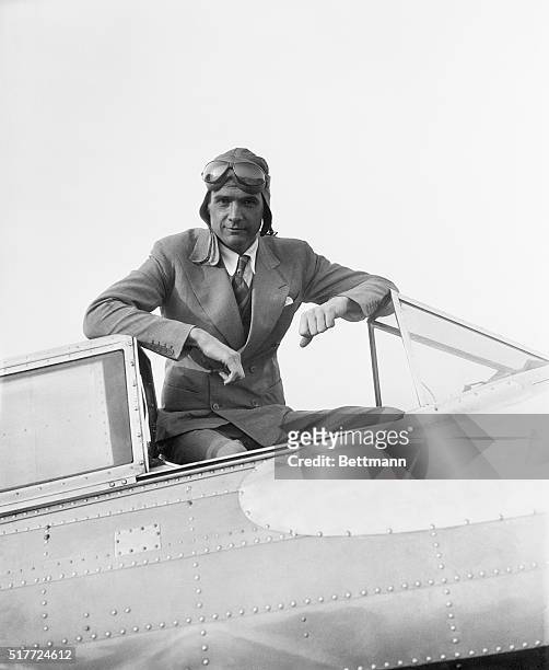 Millionaire Howard Hughes in aviator's gear seated in his plane. Photograph, 1/14/36.