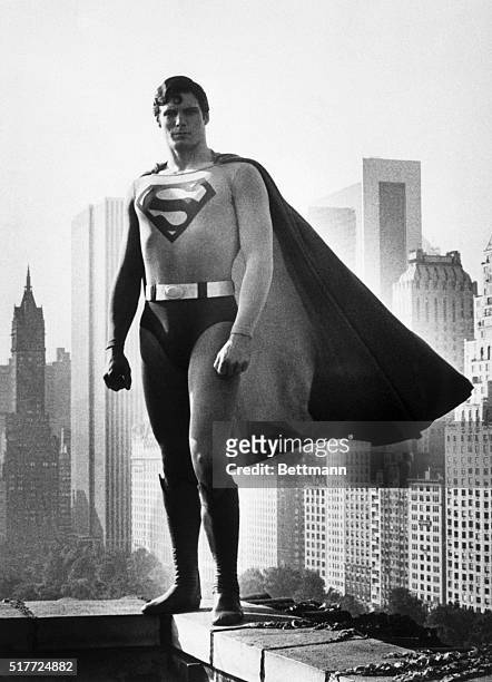 Christopher Reeve wears the cape of Superman, in the 1978 film of the same name. Reeve stands on the roof of a midtown Manhattan building.