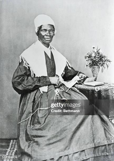 Sojourner Truth poses for a portrait while knitting at a small table. Sojourner Truth, whose legal name was Isabella Van Wagener, was born into...