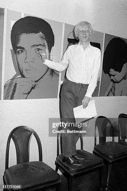 Andy Warhol touches up a painting of Muhammad Ali at his Manhattan art studio 9/5. "Working is my favorite relaxation," he says. The famed pop...
