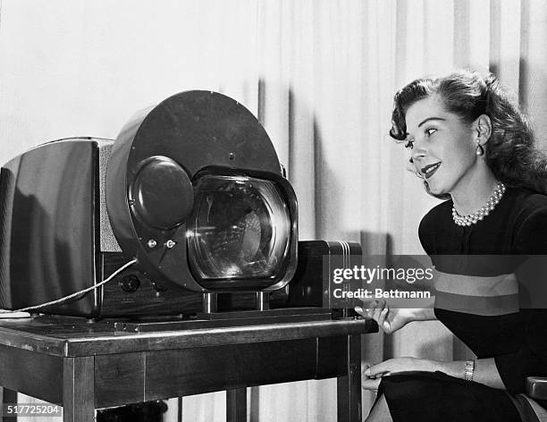 New York, NY: Janet Davis, singer, demonstrates a black-and-white television set which has been adapted and converted to receive CBS color video...