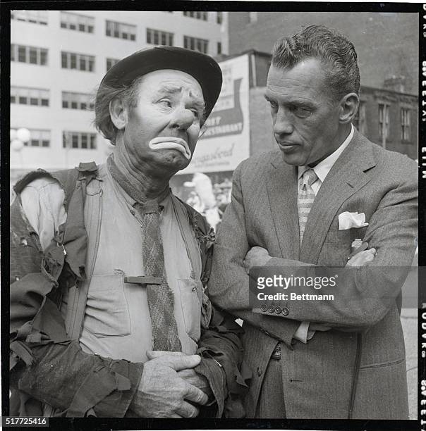 New York: Two famous sad-faced notables, circus clown Emmett Kelly and Ed Sullivan exchange poker-faced poses during a break in television rehearsals...