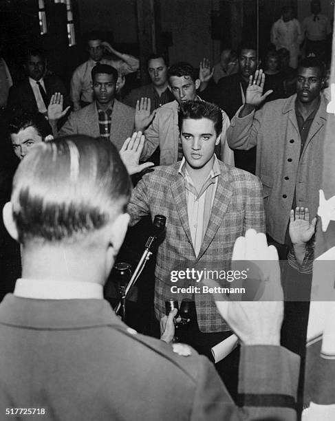 Memphis, Tennessee: Singer Elvis Presley is sworn into the army here March 24th by Maj. Elbert P. Turner . The 23-year old Rock 'N' Roll singing star...