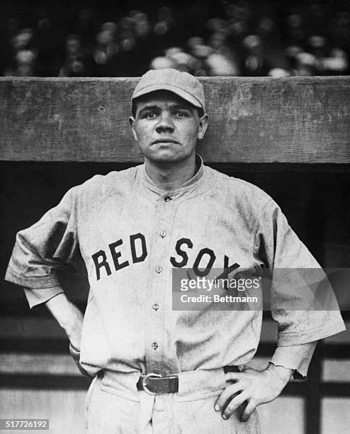 Babe Ruth wearing the uniform of the Boston Red Sox, the team he played with from 1915 until he joined the Yankees in 1920, Half length photograph.