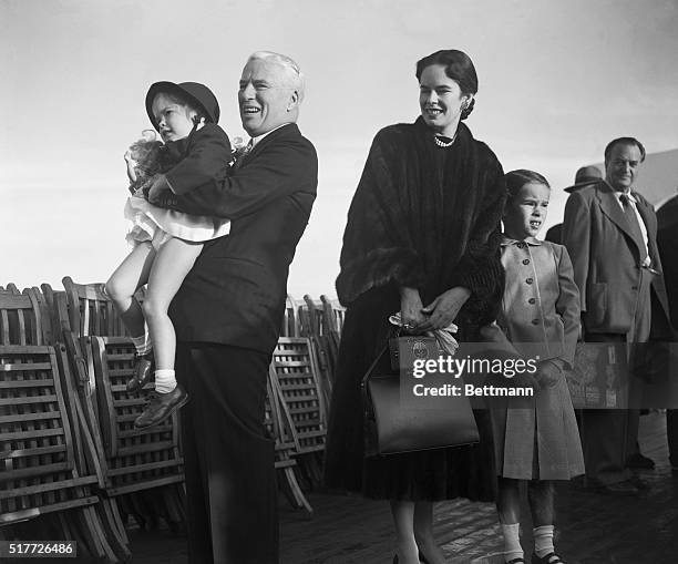 Southampton, England: Back in his native for the first time in 21 years, movie comedian Charles Chaplin is shown holding up his daughter Josephine...