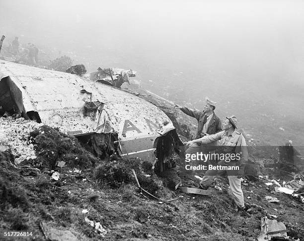 Two U.S. Air Force officers from the USAF base at Lajes are shown examining wreckage of the Air France Constellation that crashed on an Azores...