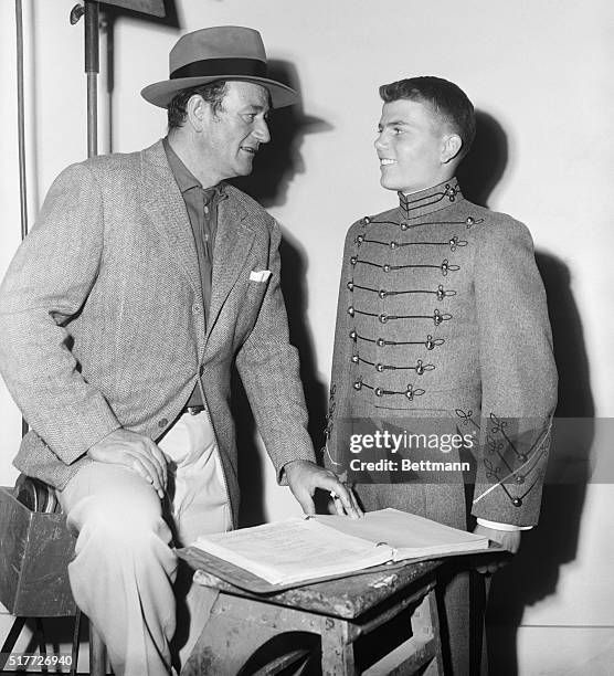 Hollywood, California: Actor John Wayne helps his son Pat with his lines for "The Long Gray Line" in which Pat makes his screen debut. The younger...