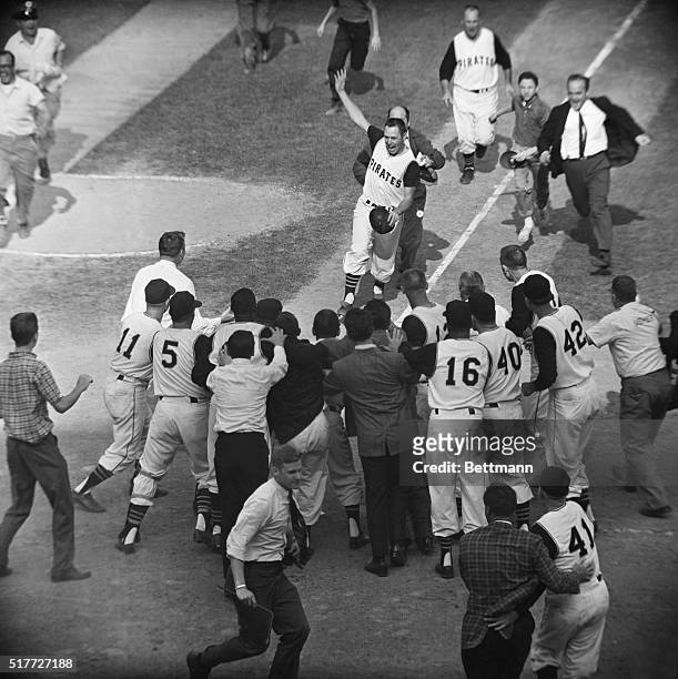 Pittsburgh, PA: Pirate Bill Mazeroski chased by a fan gets ready to cross home plate and is greeted by fans and fellow players after his ninth inning...