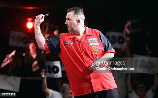 Phil Taylor in action as the fans celebrate Andy Fordham scoring a 180 during their showdown match at The Circus Tavern on November 21, 2004 in...