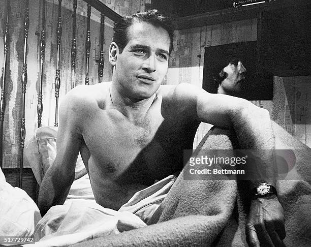 Portrait of actor, Paul Newman, sitting up in bed with no shirt on. Undated photo circa 1950s.