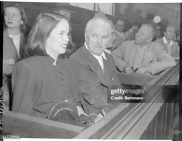 Charles Chaplin and Wife at Tennis Match. Los Angeles, CA.:Charlie Chaplin and his wife, Oona O'Neill, daughter of the famous playwright, view the...