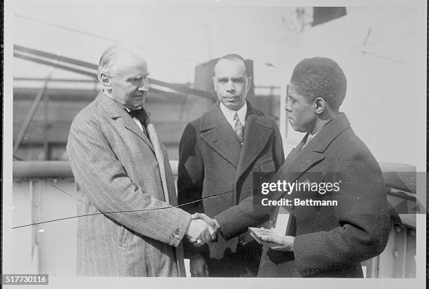 Walter Damrosh congratulates Roland Hayes, negro lyric tenor, after he had awarded Hayes with the Sprigarn medal. Standing in the center is James W....