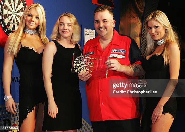 Phil Taylor poses with his prize after Andy Fordham conceded due to illness during the Showdown match at The Circus Tavern November 21, 2004 in...