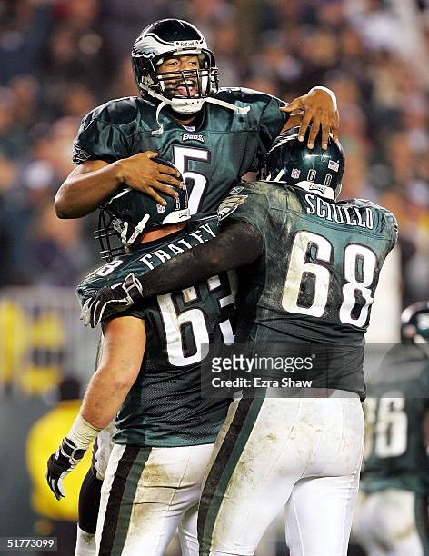 Donovan McNabb of the Philadelphia Eagles jumps into the arms of teammates Hank Fraley and Steve Sciullo after McNabb threw a touchdown pass to Brian...