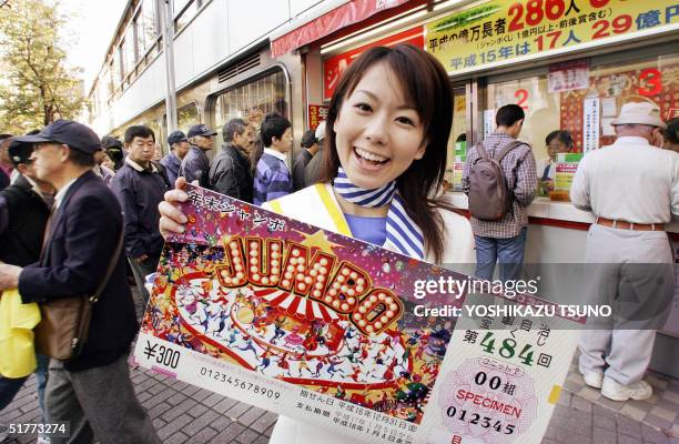 Campaign girl Yumiko Kataoka shows off a large sample ticket of the 300 million yen Year-end Jumbo Lottery before a Tokyo ticket booth 22 November...