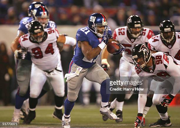 Running back Tiki Barber of the New York Giants rushes against defensive end Travis Hall, tackle Chad Lavalais, linebackers Matt Stewart and Chris...