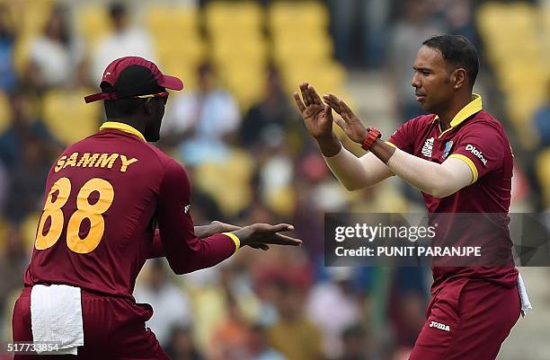 West Indies bowler Samuel Badreecelebrates with captain Darren Sammy after taking the wicket of unseen Afghanistan batsman Usman Ghani during the...