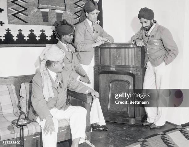 Left to right, Mr. A. M. Hayman, Dhyan Chand, Moh'd [. . .] and Gurmit Singh as they listen to the radio in the lobby of the administration building...