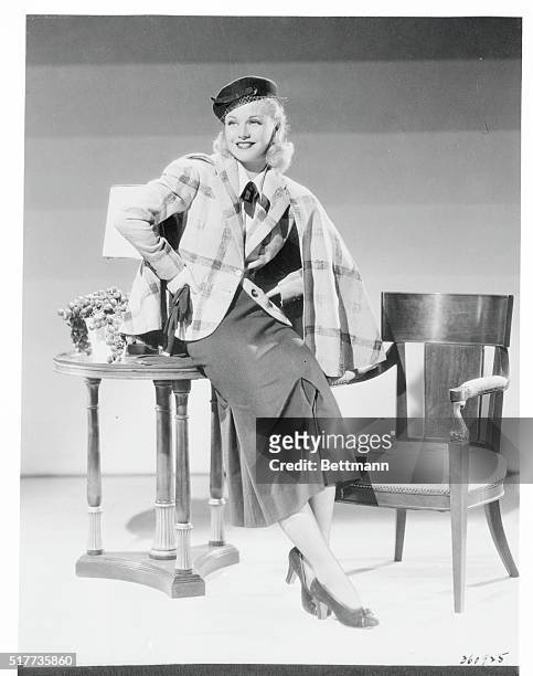 Honey beige and brown plaid wool creates the tailored jacket to the pictured suit which Ginger Rogers, RKO Radio star wears. The skirt is dark brown...