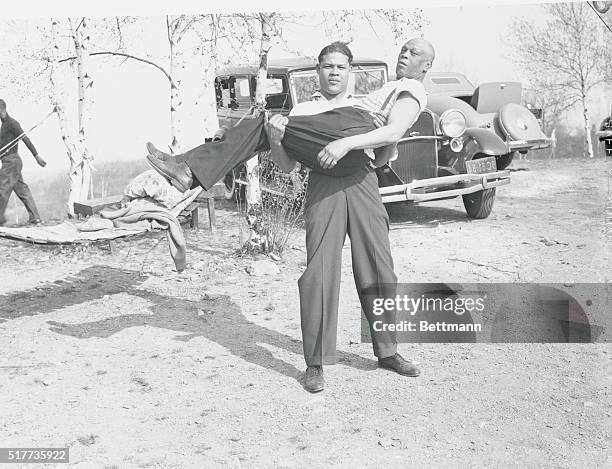 Rock-a-bye Blackburn...After Joe Louis' strenuous workout, at his training camp in Lafayetteville, N.Y., where he is shaping up for his forthcoming...