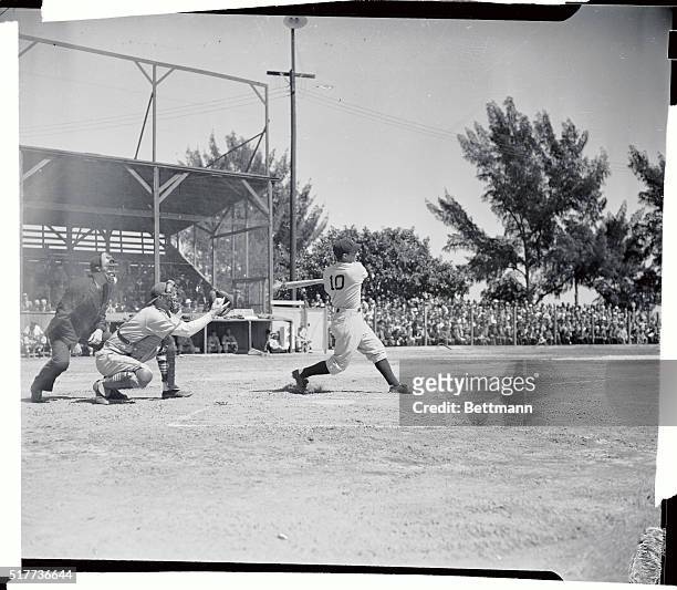 Shortstop Phil Rizzuto of the World's Champion New York Yankees, is out, swinging, as first man up in the Yankees' first game of the spring training...