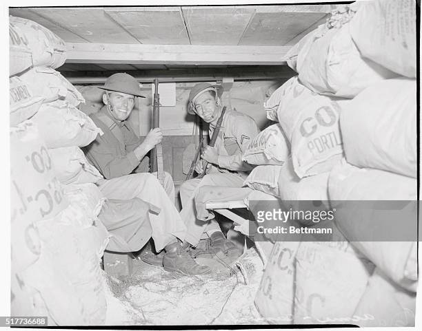 Soldiers in dugout, commonly referred to as "rat hole", are, left to right: Private First Class Lionel Cota, of St. Albans, Vermont., and P.F.C. A.M....