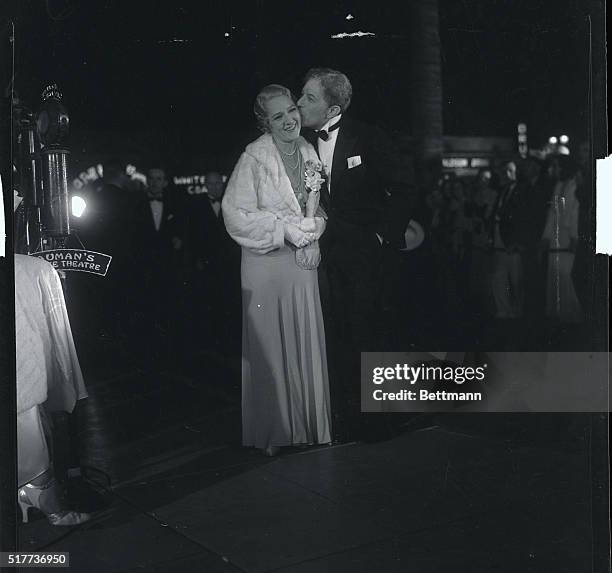 Mary Pickford, former queen of American films, receives a fatherly kiss from Sid Grauman, veteran showman, as she arrives for premiere of, Rain,...