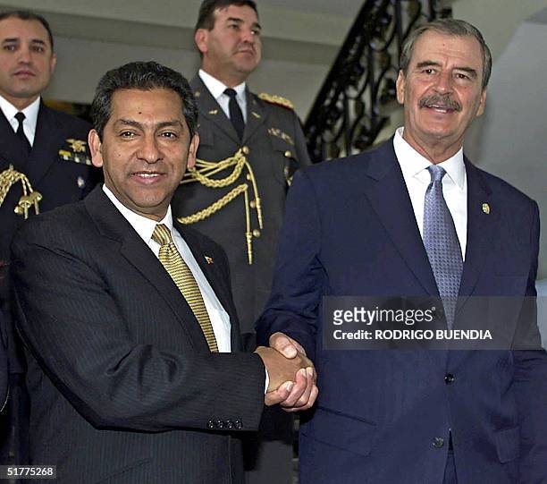 El presidente de Mexico Vicente Fox saluda a su homologo de Ecuador Lucio Gutierrez en el Palacio de Carondelet en Quito el 22 de noviembre de 2004....