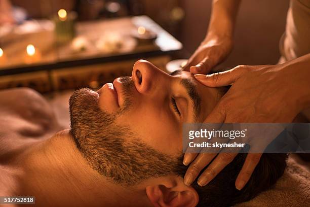 primer plano de un hombre que recibió masaje facial en el spa. - head massage fotografías e imágenes de stock